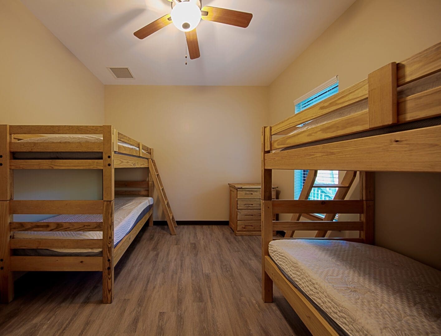 Bedroom with wooden bunk beds and fan.