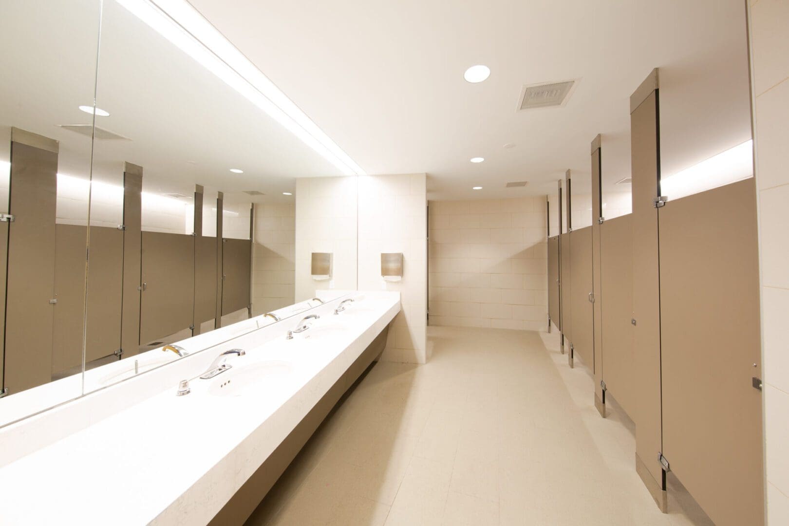 Modern public restroom with stalls and sinks.