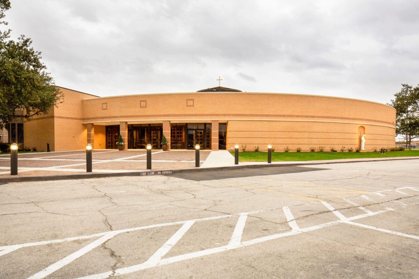 Modern circular building with cloudy sky background.