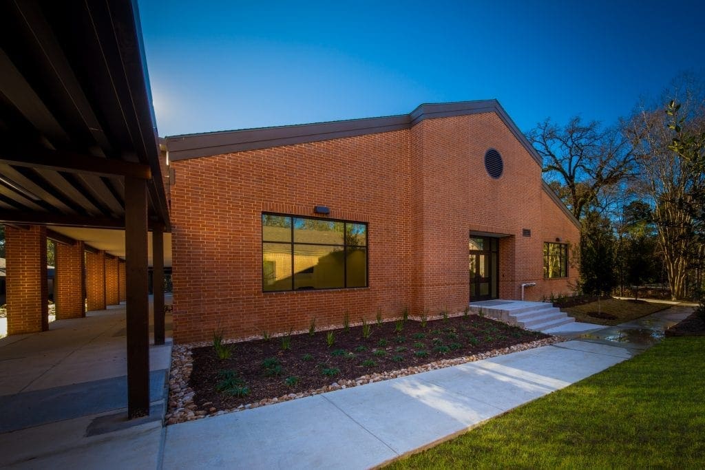 Modern brick building with landscaped entrance.