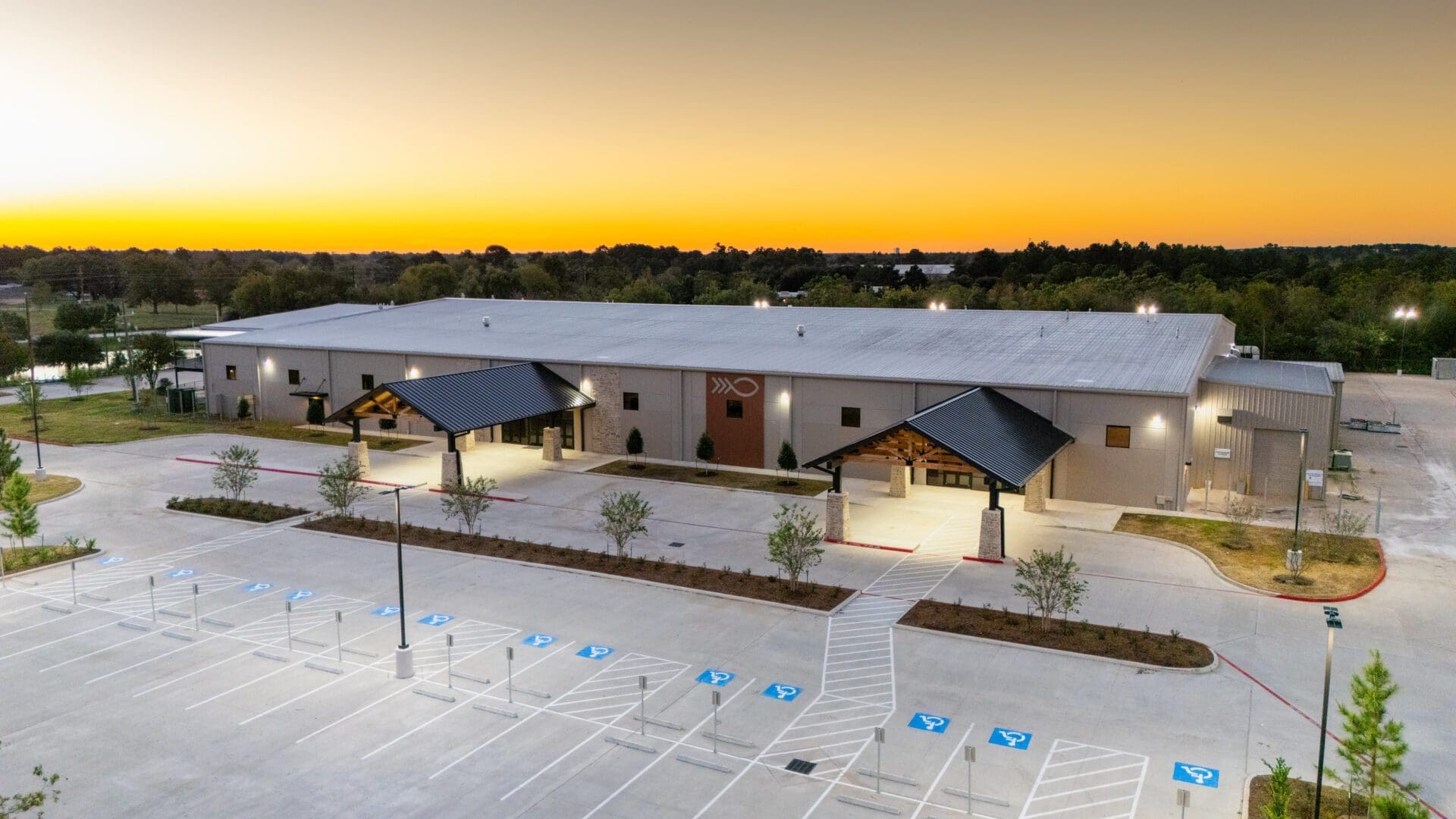 Building at sunset with empty parking lot.